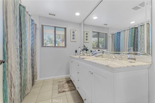 bathroom featuring tile patterned flooring, vanity, and a healthy amount of sunlight