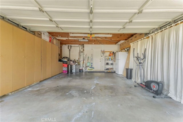 garage with white refrigerator, water heater, and a garage door opener