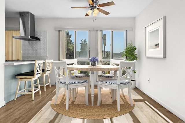 dining space with hardwood / wood-style floors and ceiling fan