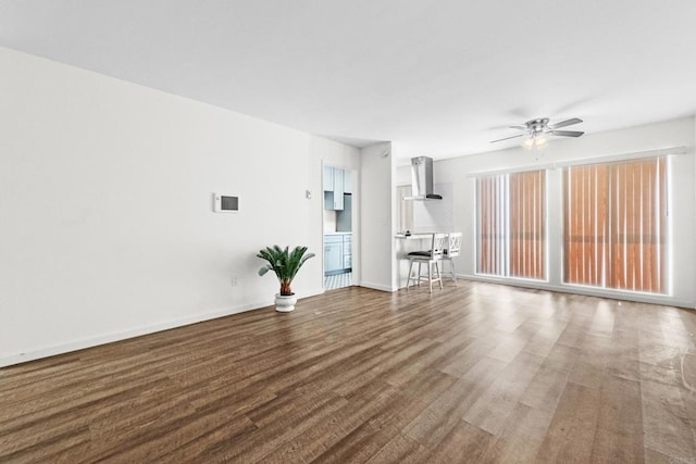 unfurnished living room featuring ceiling fan and hardwood / wood-style flooring