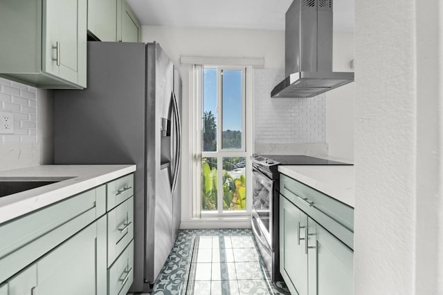 kitchen featuring island range hood, stainless steel appliances, light tile patterned floors, green cabinets, and backsplash