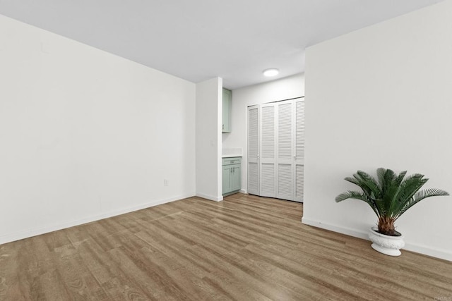 unfurnished bedroom featuring a closet, connected bathroom, and light hardwood / wood-style flooring