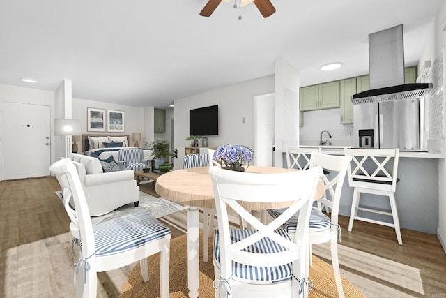 dining room with ceiling fan, light hardwood / wood-style flooring, and sink