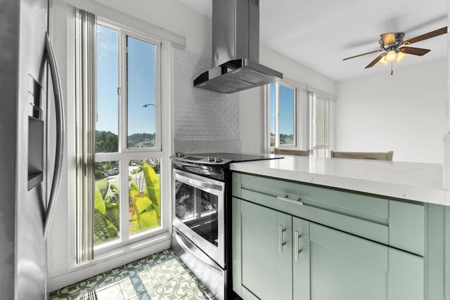 kitchen featuring stainless steel appliances, green cabinetry, ceiling fan, and island exhaust hood