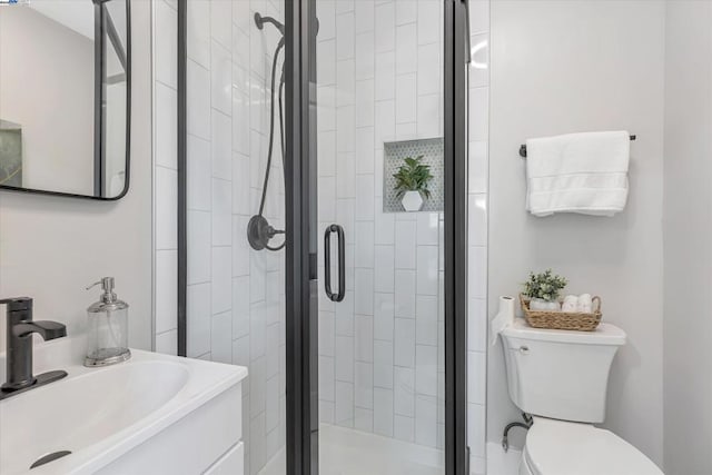 bathroom with walk in shower, vanity, and toilet