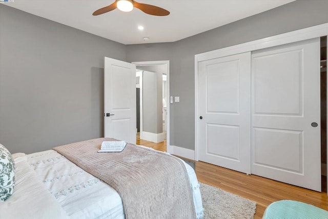 bedroom with hardwood / wood-style floors, a closet, and ceiling fan