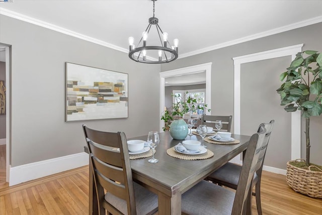 dining area featuring ornamental molding, light hardwood / wood-style floors, and a chandelier