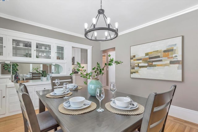 dining area featuring ornamental molding, light hardwood / wood-style floors, and a chandelier