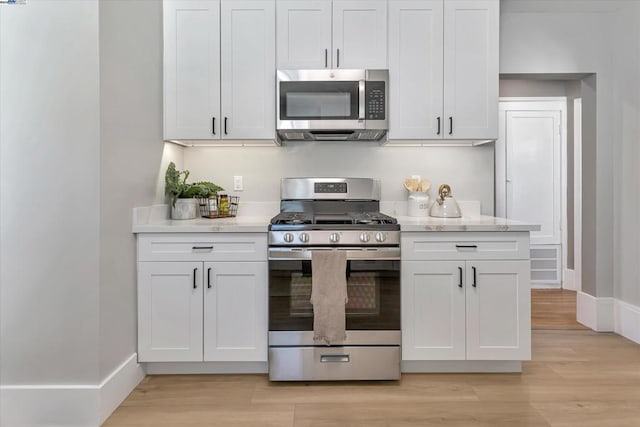 kitchen featuring white cabinets, appliances with stainless steel finishes, and light hardwood / wood-style floors