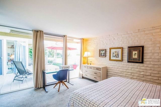 carpeted bedroom featuring brick wall and a wall of windows