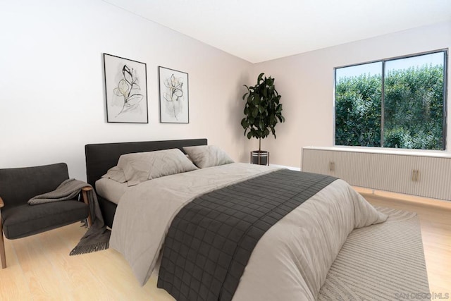 bedroom featuring light wood-type flooring and radiator heating unit