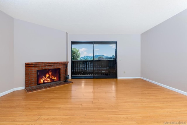 living room featuring a tiled fireplace and light hardwood / wood-style flooring