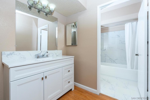 bathroom featuring a textured ceiling, vanity, hardwood / wood-style flooring, and shower / tub combo with curtain