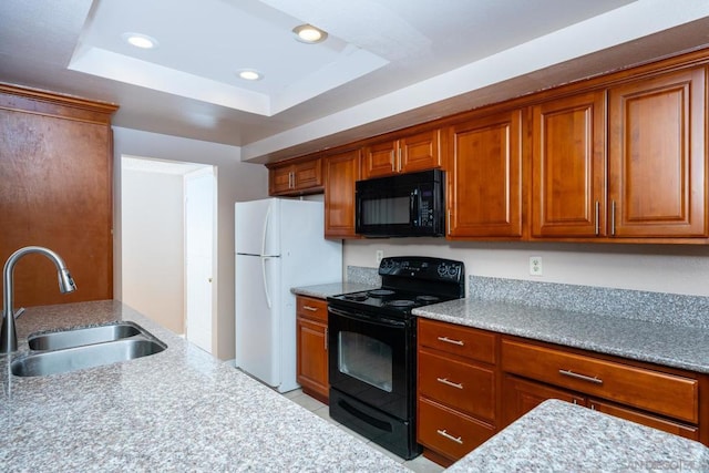 kitchen featuring black appliances, a raised ceiling, and sink