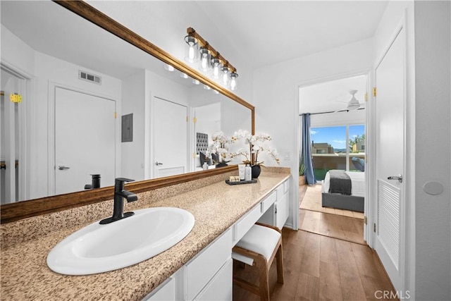 bathroom with wood-type flooring, vanity, and ceiling fan