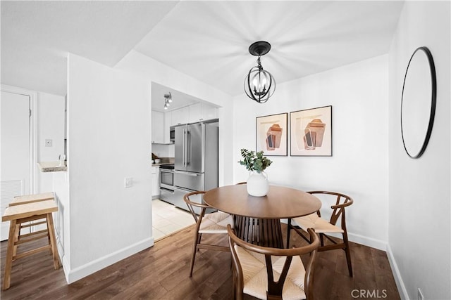 dining space featuring hardwood / wood-style flooring and a notable chandelier