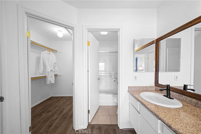 full bathroom with vanity, hardwood / wood-style floors, shower / bathtub combination, and toilet