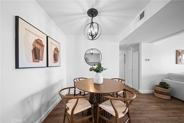 dining area with dark hardwood / wood-style flooring and a notable chandelier