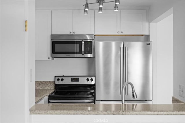 kitchen featuring light stone countertops, white cabinets, and appliances with stainless steel finishes