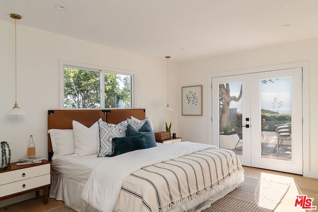 bedroom featuring french doors, light wood-type flooring, and access to exterior