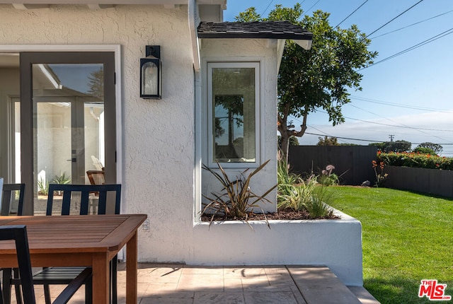 entrance to property featuring a yard and a patio