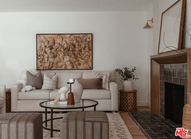 living room with a tile fireplace and dark hardwood / wood-style floors