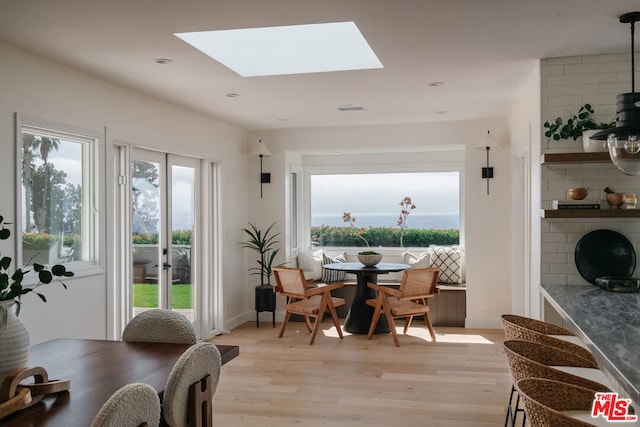 dining space featuring a skylight and light hardwood / wood-style floors