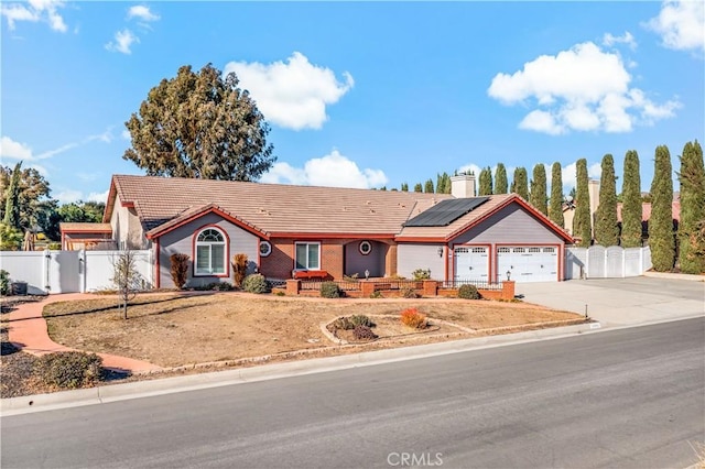 single story home with solar panels and a garage