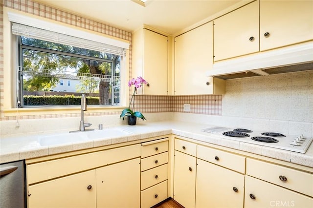 kitchen with stainless steel dishwasher, tile counters, decorative backsplash, white electric cooktop, and sink