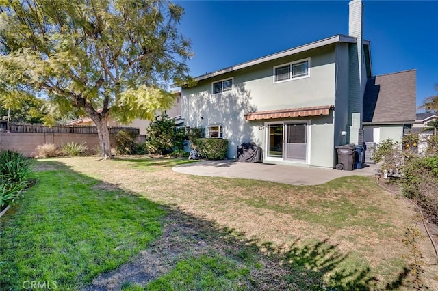 rear view of house with a patio area and a lawn