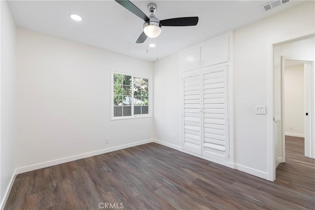 unfurnished bedroom featuring dark hardwood / wood-style floors, ceiling fan, and a closet