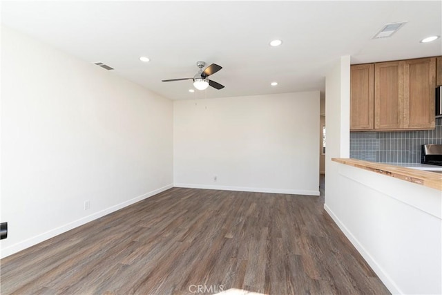 empty room featuring dark wood-type flooring and ceiling fan