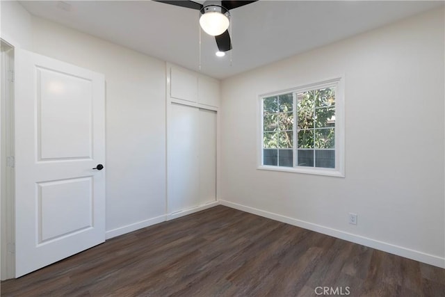 unfurnished bedroom featuring dark hardwood / wood-style flooring, a closet, and ceiling fan