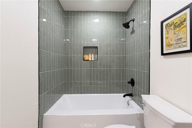 bathroom with tiled shower / bath and toilet