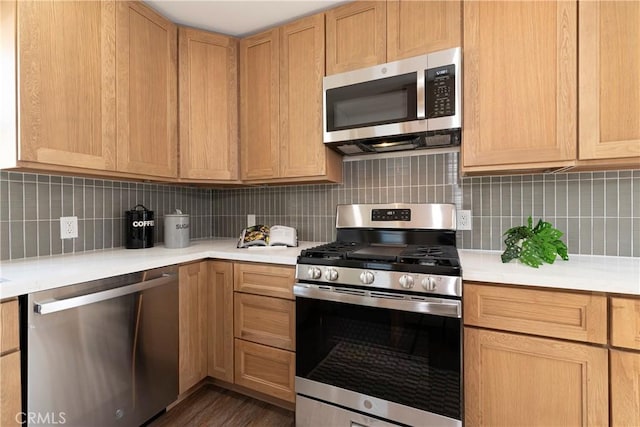 kitchen with backsplash, light brown cabinets, and appliances with stainless steel finishes