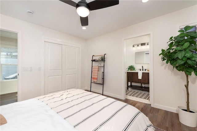 bedroom featuring dark wood-type flooring, ceiling fan, ensuite bath, and a closet