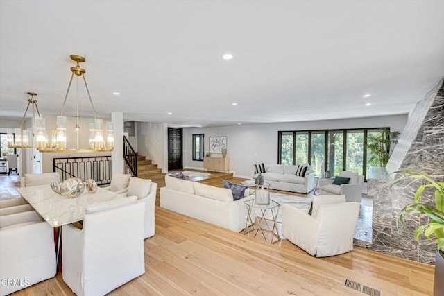 living room featuring light hardwood / wood-style floors and a notable chandelier