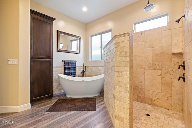 bathroom featuring tile walls, wood-type flooring, and shower with separate bathtub