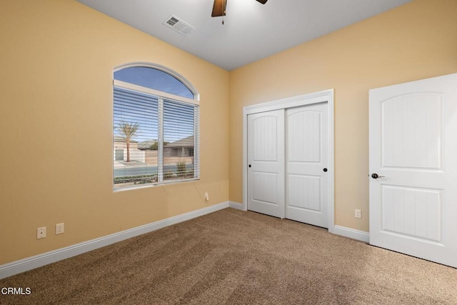 unfurnished bedroom with ceiling fan, a closet, and carpet flooring