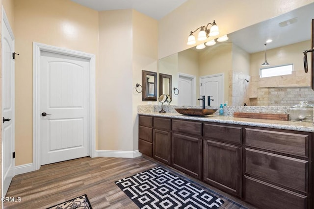 bathroom with a shower, vanity, and wood-type flooring