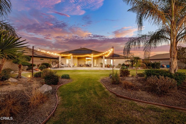 view of front facade featuring a lawn and a patio