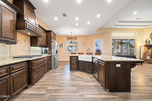 kitchen featuring dark brown cabinets, appliances with stainless steel finishes, pendant lighting, and sink