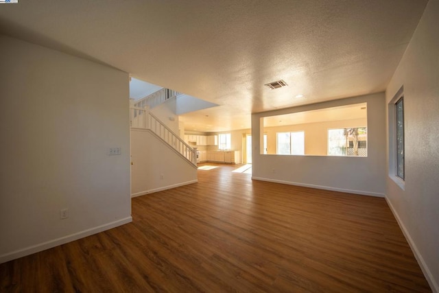 empty room featuring a textured ceiling and hardwood / wood-style floors