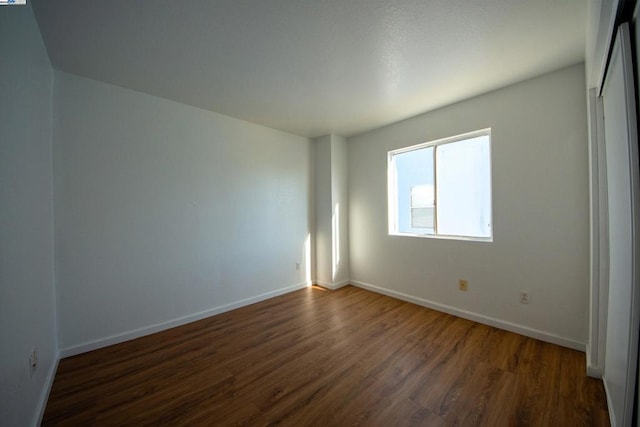 spare room with dark hardwood / wood-style flooring