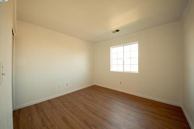 unfurnished room with dark wood-type flooring