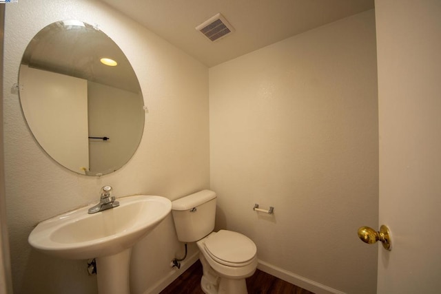 bathroom with toilet and wood-type flooring