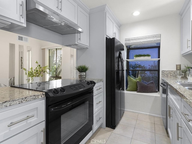 kitchen with black appliances, light stone countertops, sink, white cabinetry, and light tile patterned flooring