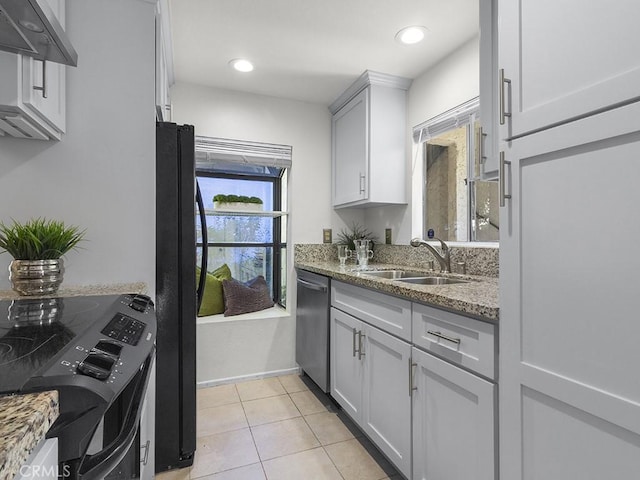 kitchen featuring dishwasher, black fridge, wall chimney exhaust hood, sink, and stone countertops