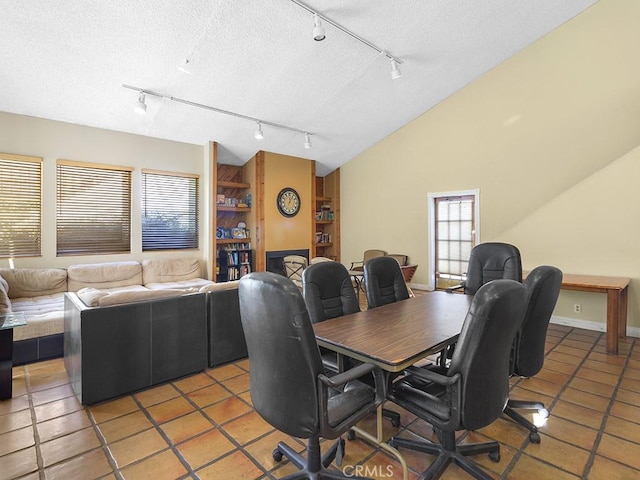 tiled dining room with a textured ceiling and lofted ceiling