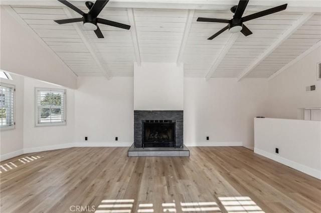 unfurnished living room with ceiling fan, vaulted ceiling with beams, light hardwood / wood-style flooring, and a fireplace